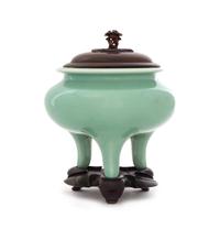 A Japanese Celadon Glazed Porcelain Tripod Incense Burner Height 4 3/4 inches. — PORCELAIN: EARLY 20TH CENTURYWOOD COVER AND STAND: CHINESE, 19TH CENTURY