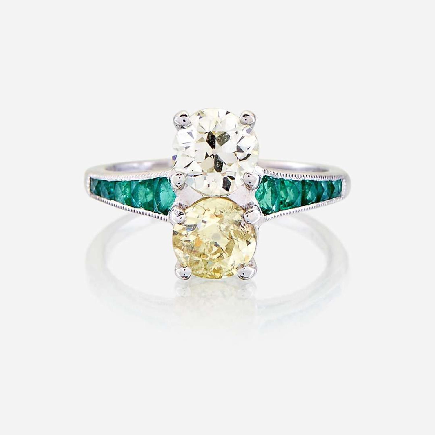 A fancy yellow diamond, diamond, emerald, and platinum ring