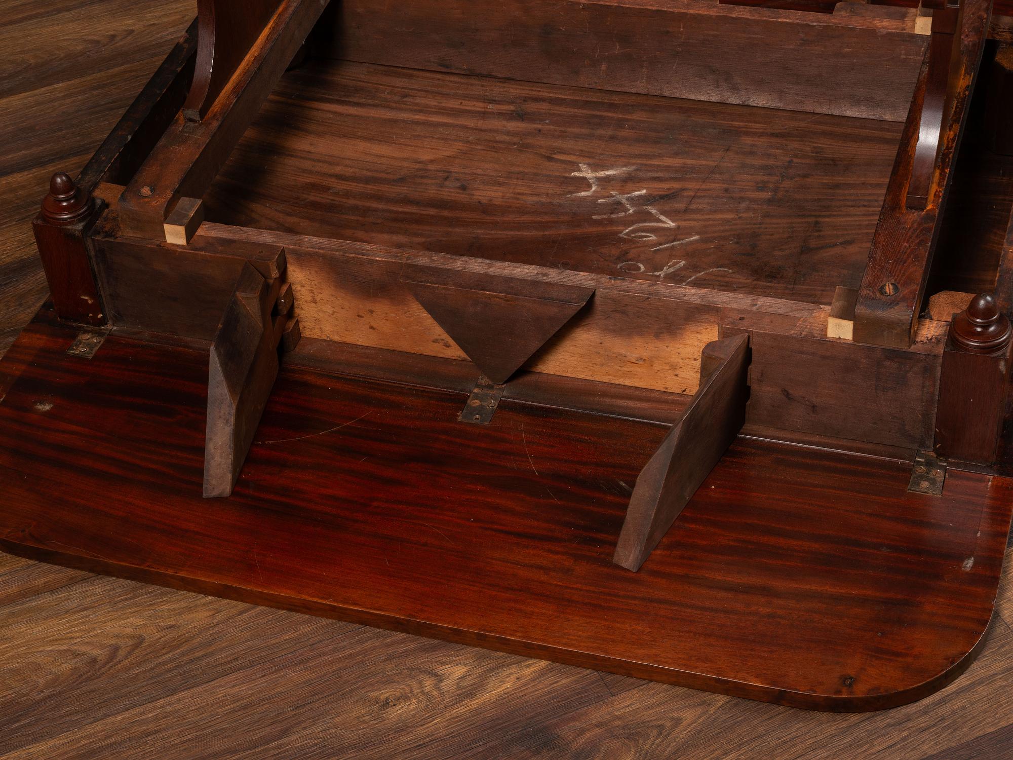 A Classical Parcel Gilt and Ebonized, Figured Mahogany Paw-Foot Drop-Leaf Table