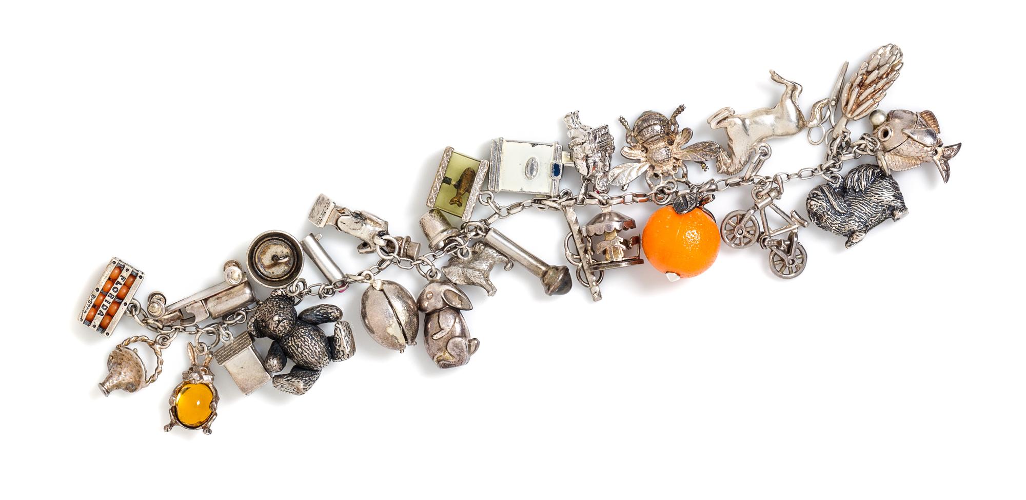 A Vintage Sterling Silver Charm Bracelet with Numerous Attached Charms, 55.60 dwts.