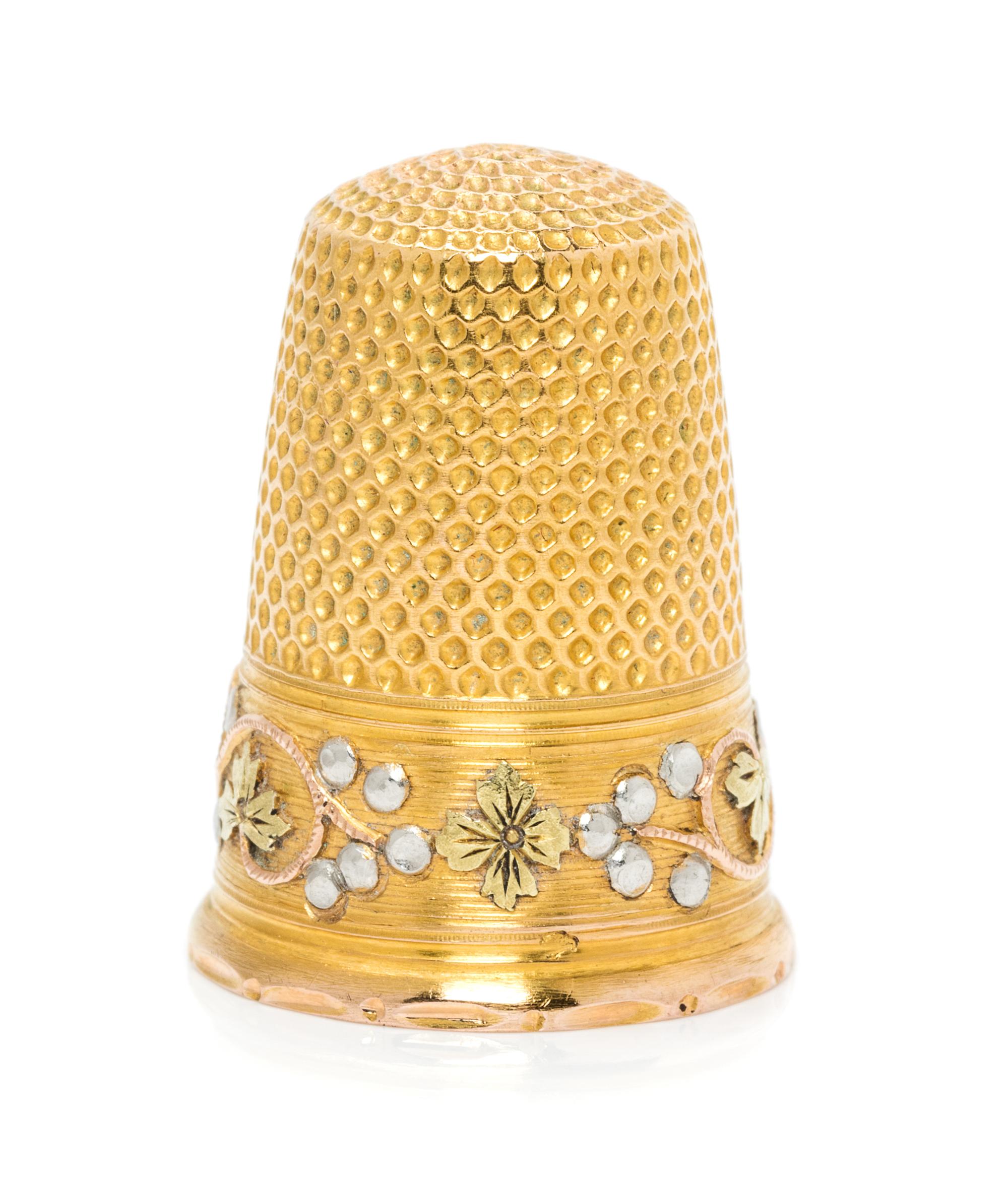 A French Tri-Colored Gold Thimble, , the knurled top and body above a rose, white and yellow gold band worked to show foliate and berry