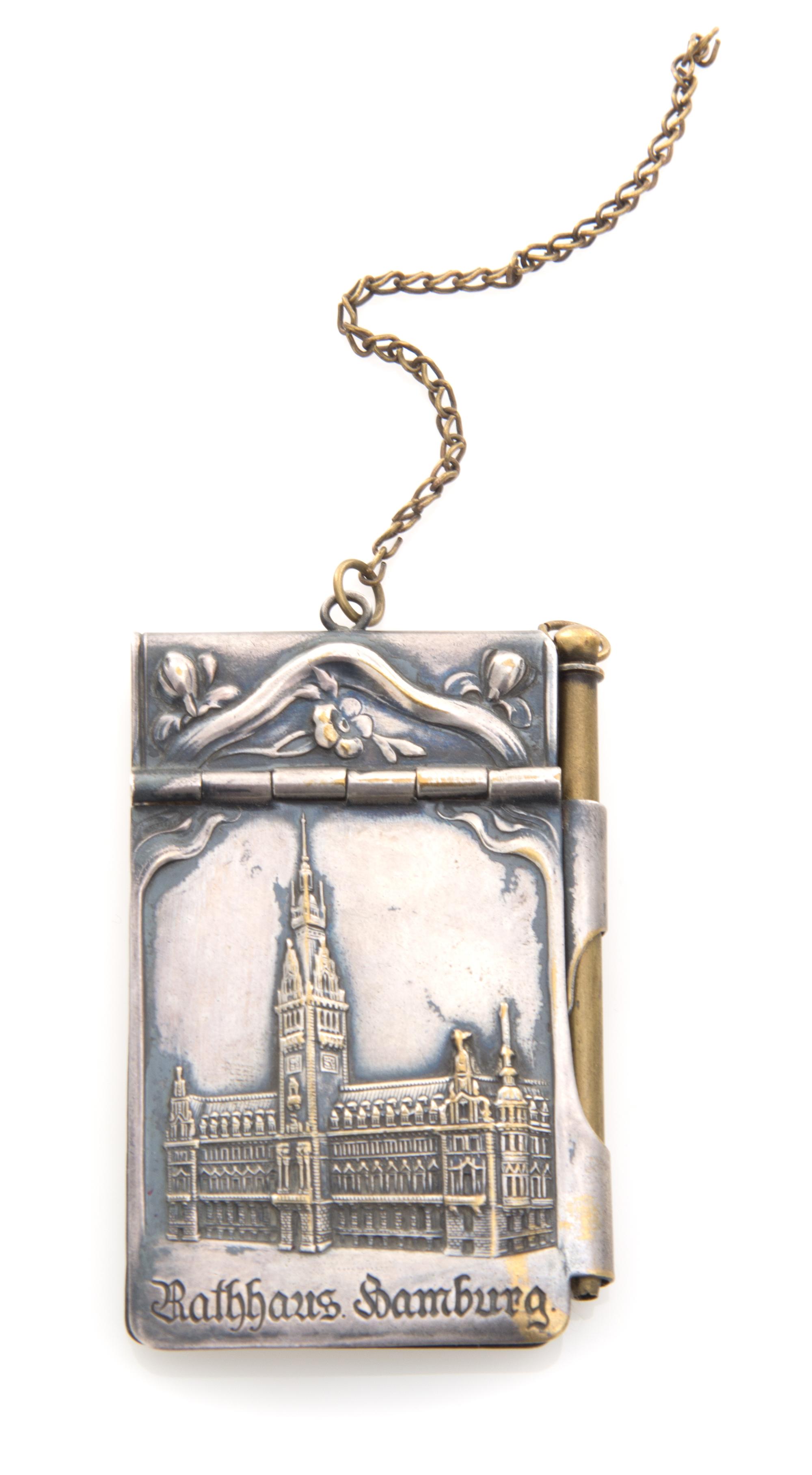 A Continental Silver Chatelaine Notepad, , the case worked to show flowering branches and opening to a partial sheet of stamp-cut paper
