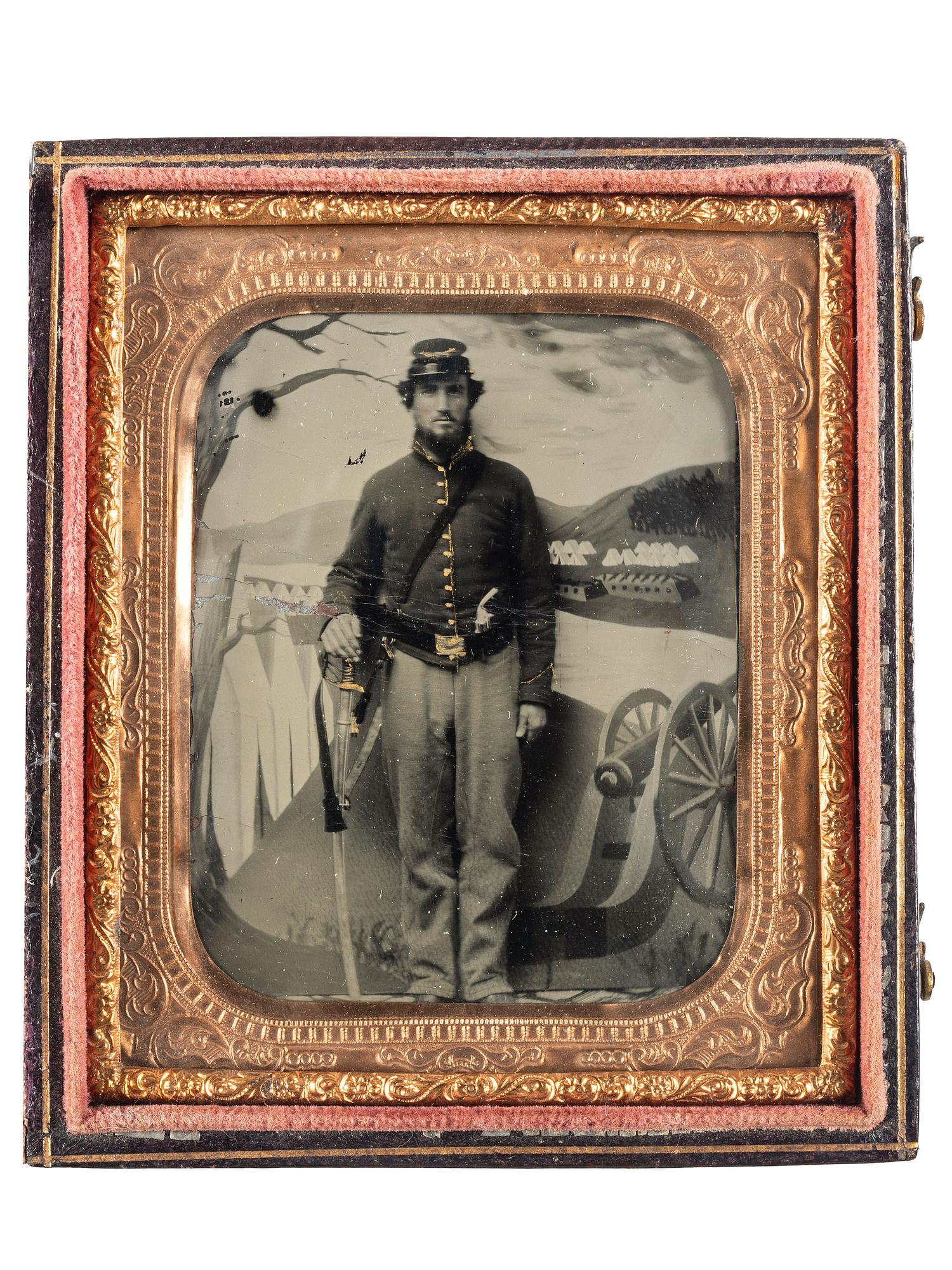 [CIVIL WAR]. Tintype of a Union cavalryman with saber and pistol, posed before painted camp scene.