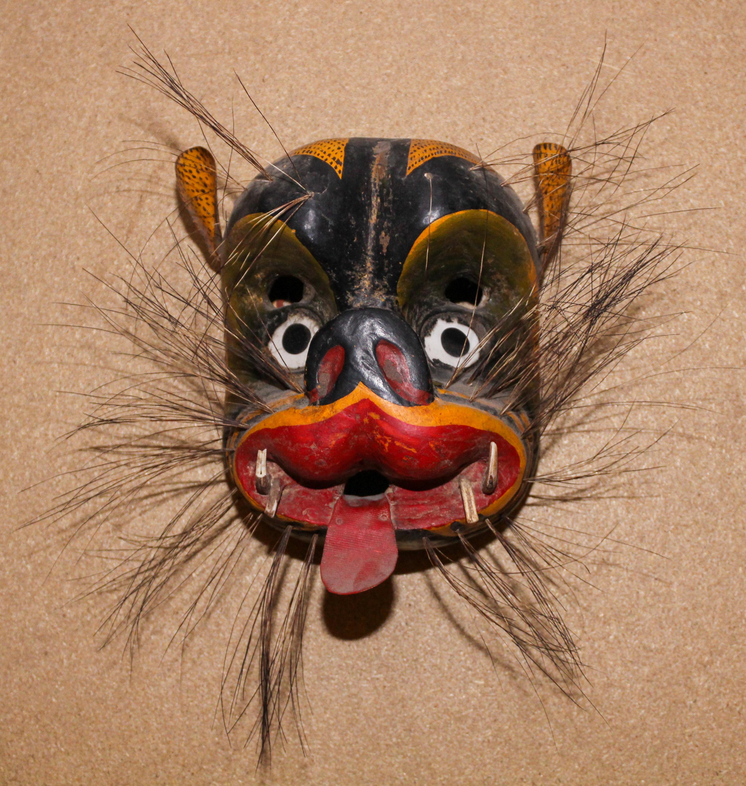 A Mexican Polychromed Wood Mask of a Beast Height 11 inches.