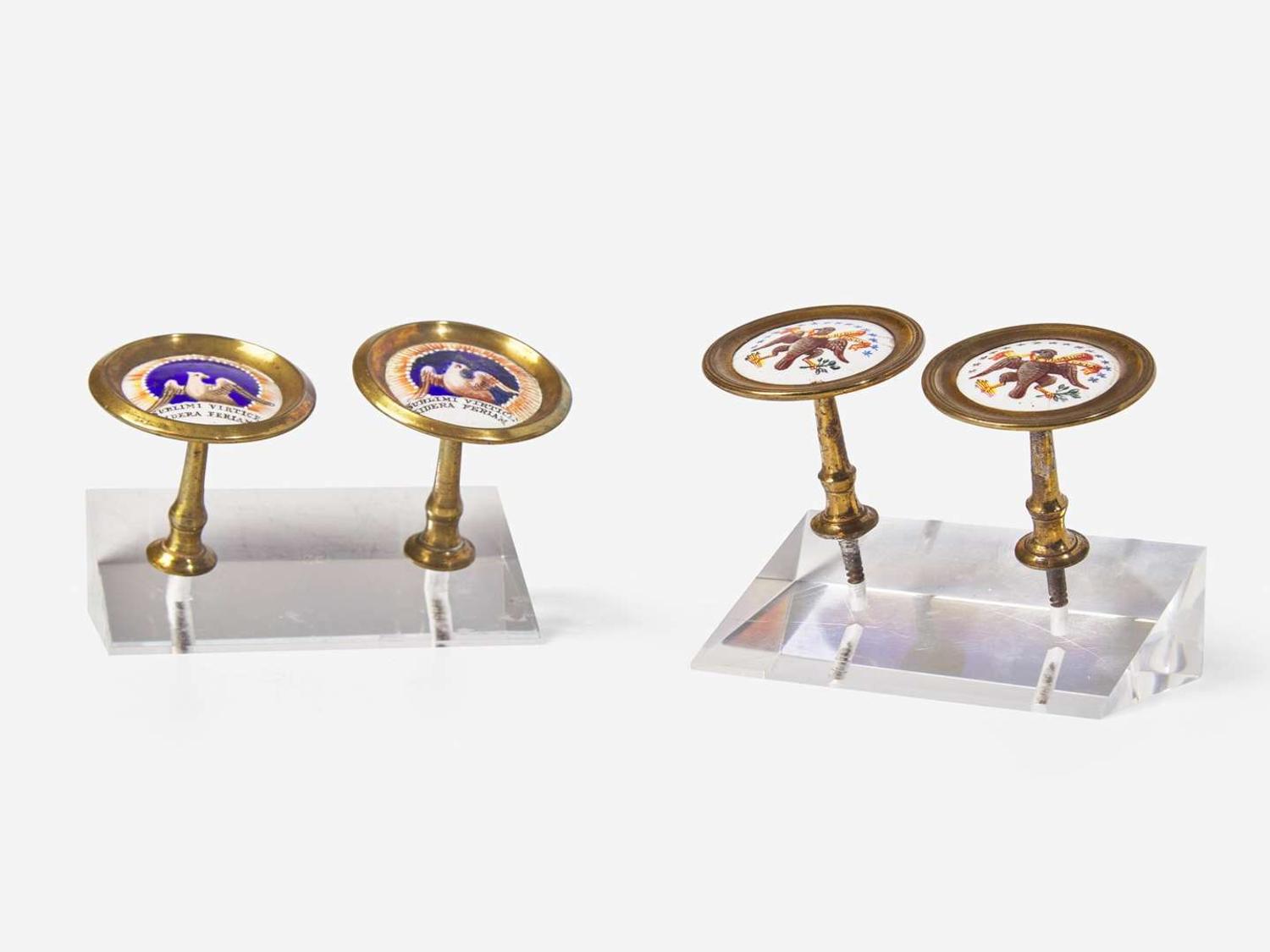 Four polychrome enameled porcelain and brass cloak pins or mirror supports with an American eagle and motto, England, early 19th century