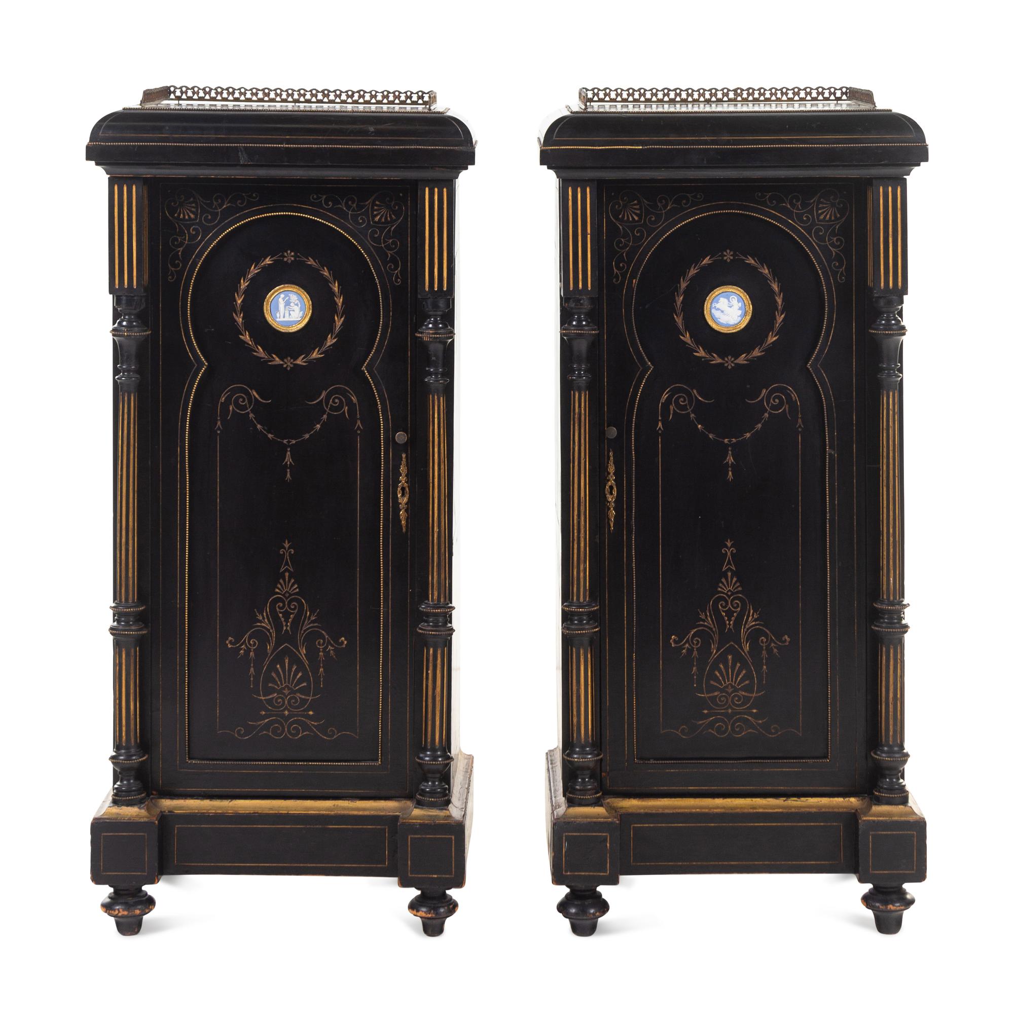 A Pair of English Aesthetic Jasperware Medallion-Mounted Ebonized and Parcel-Gilt Pedestal Cabinets