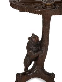A Swiss Black Forest Carved Wood Smoking Table