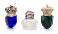 A Group of Three Silver Mounted Glass Scent Bottles, Apparently Unmarked, comprising two colored glass examples and one clear example.