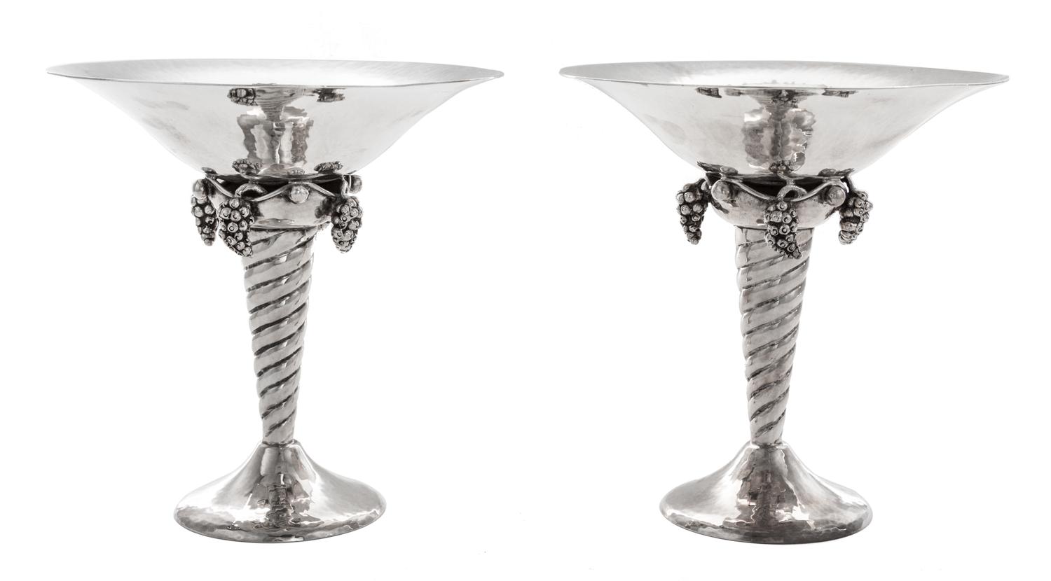 A Pair of Silver Compotes, , after the design by Georg Jensen, each having a flared bowl above pendant grape clusters and a twist stem,