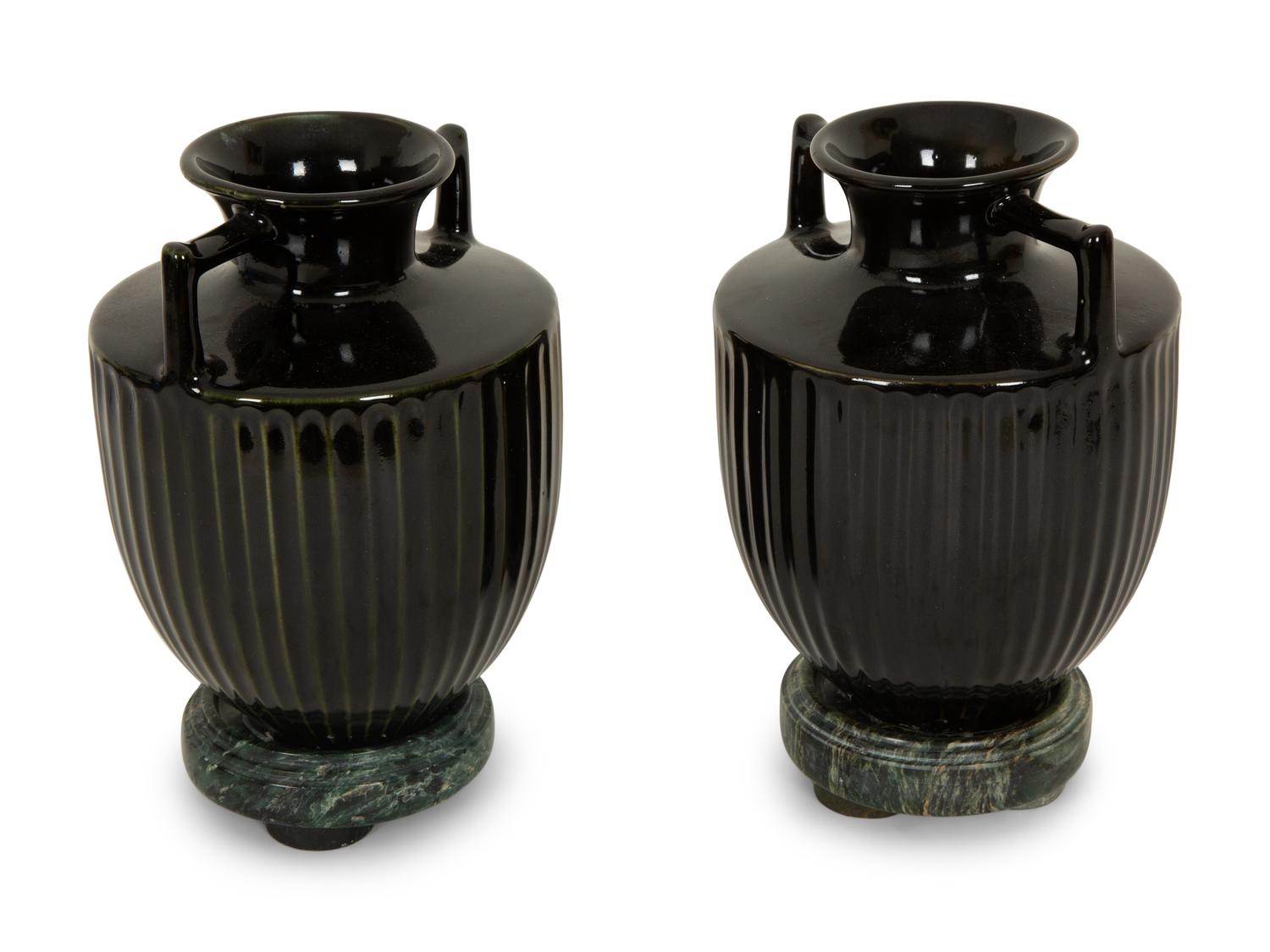 A Pair of Black Porcelain Urns on Green Marbelized Bases