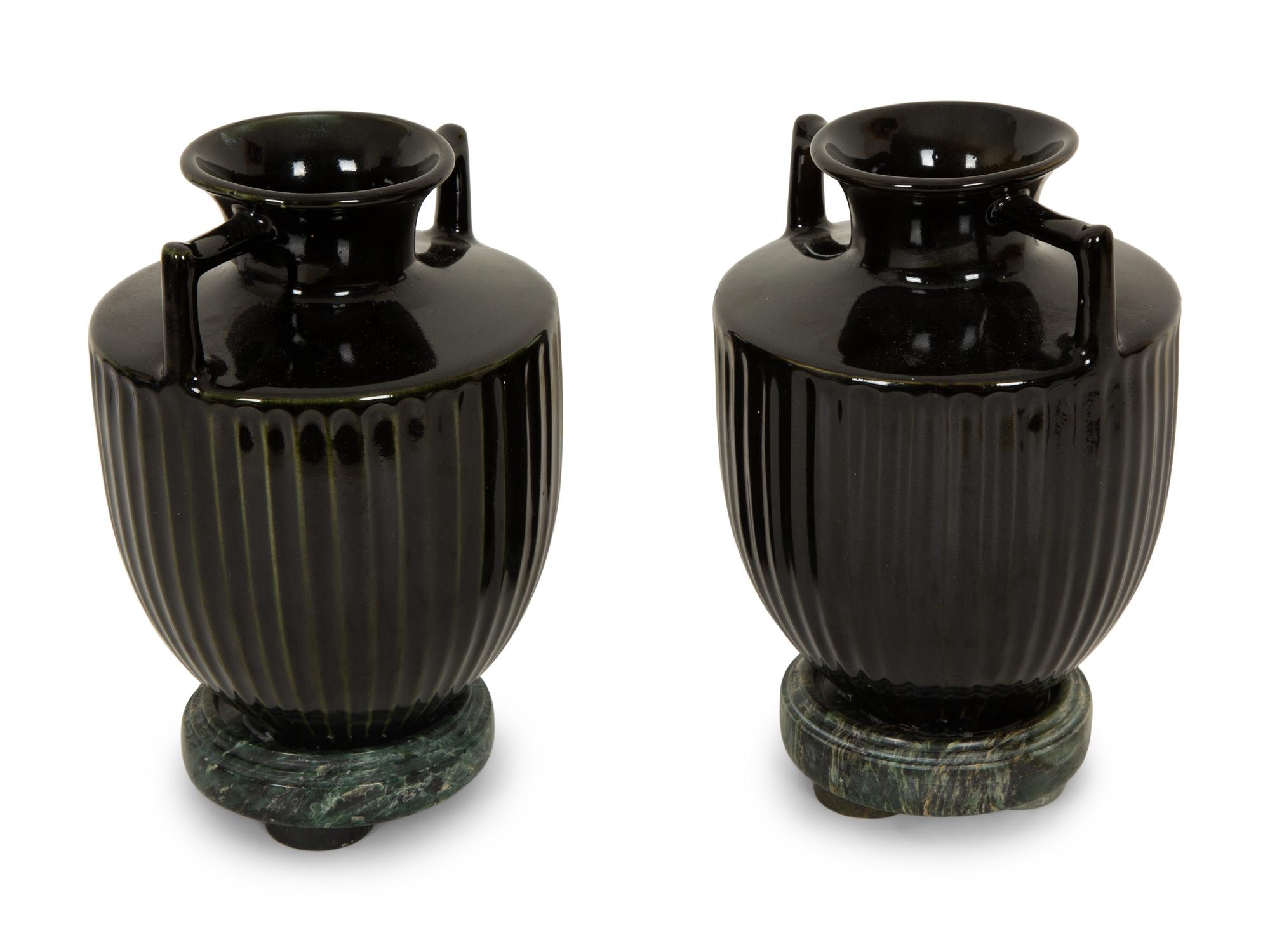 A Pair of Black Porcelain Urns on Green Marbelized Bases