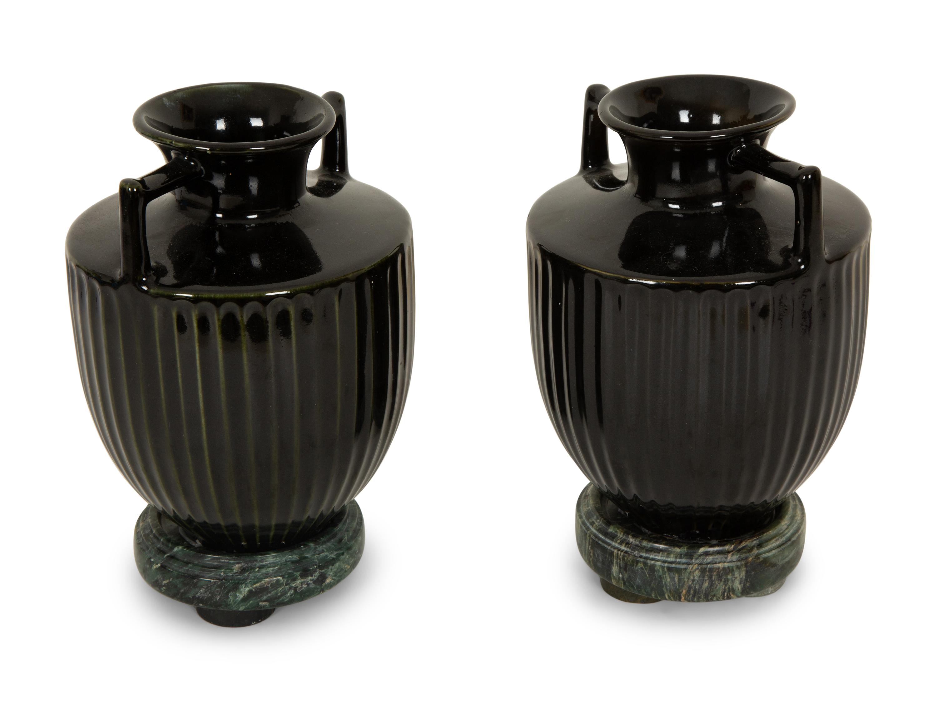 A Pair of Black Porcelain Urns on Green Marbelized Bases