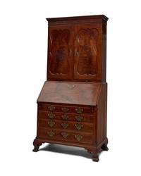 A Chippendale Figured and Carved Walnut Desk-and-Bookcase