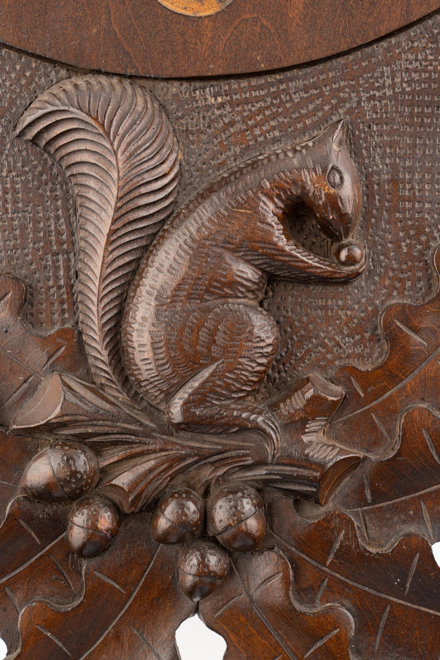 A Swiss "Black Forest" Carved Walnut Wall Clock
