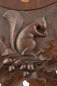 A Swiss "Black Forest" Carved Walnut Wall Clock