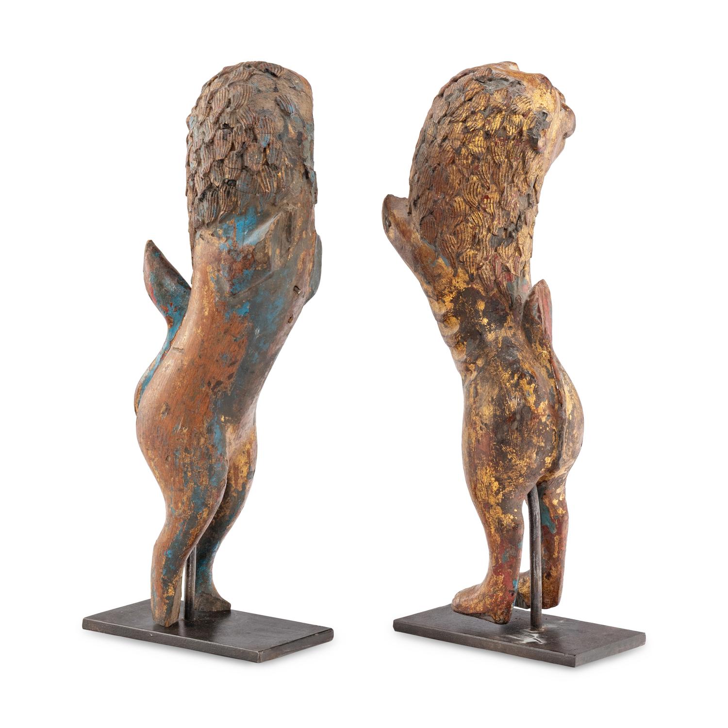 A Pair of Parcel-Gilt and Polychrome Decorated Lion-Form Crest Supporters