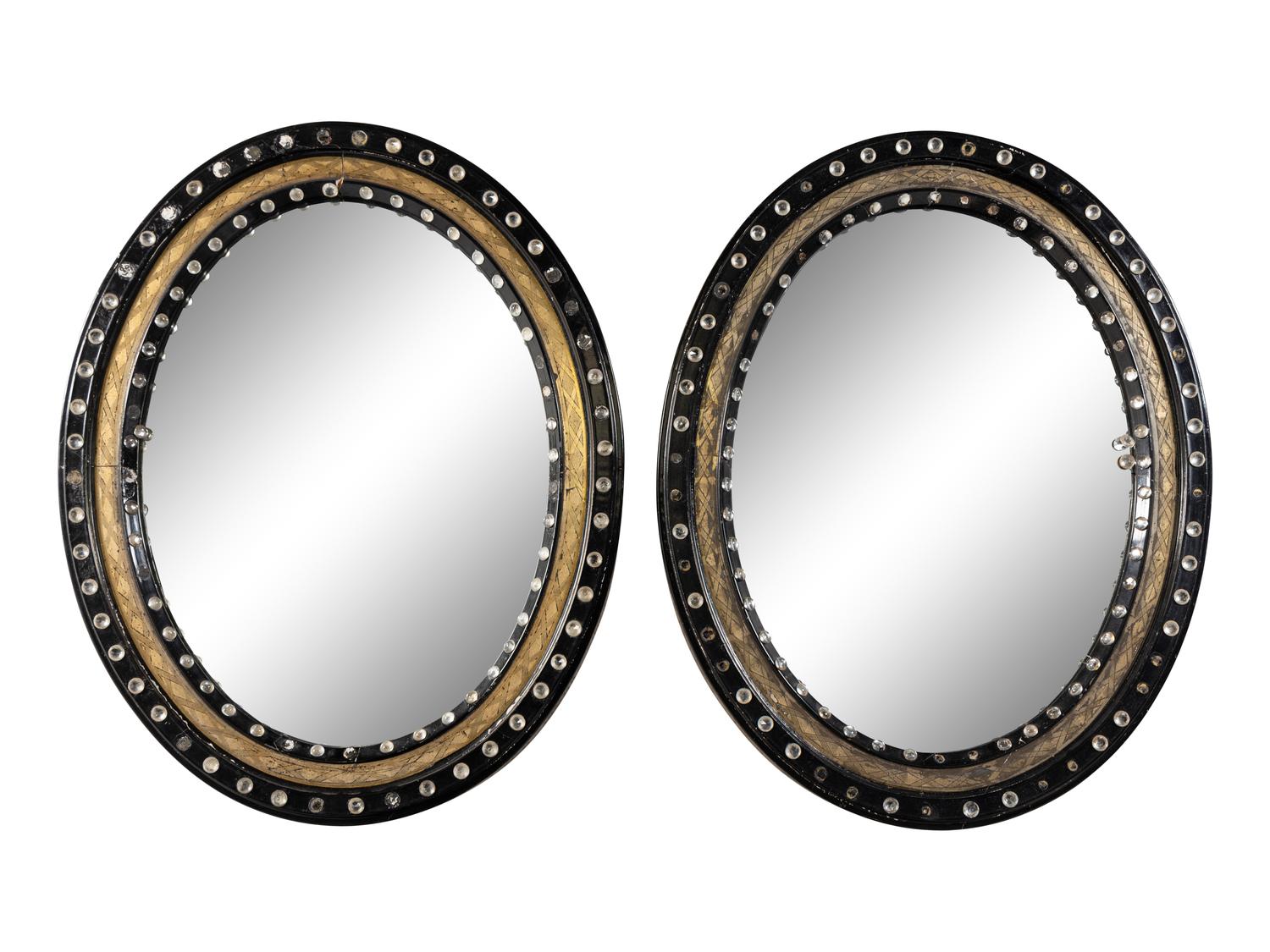 A Pair of Irish Ebonized and Parcel-Gilt Oval Mirrors