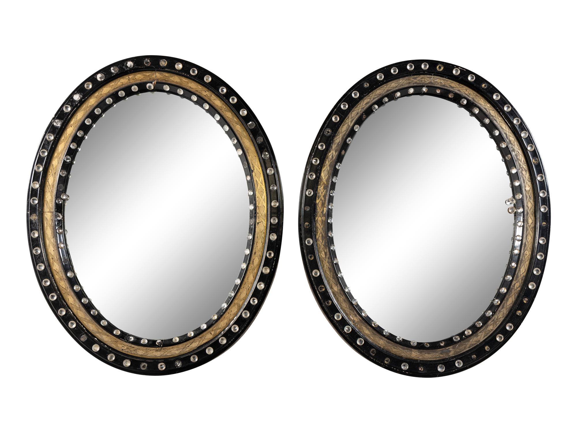 A Pair of Irish Ebonized and Parcel-Gilt Oval Mirrors