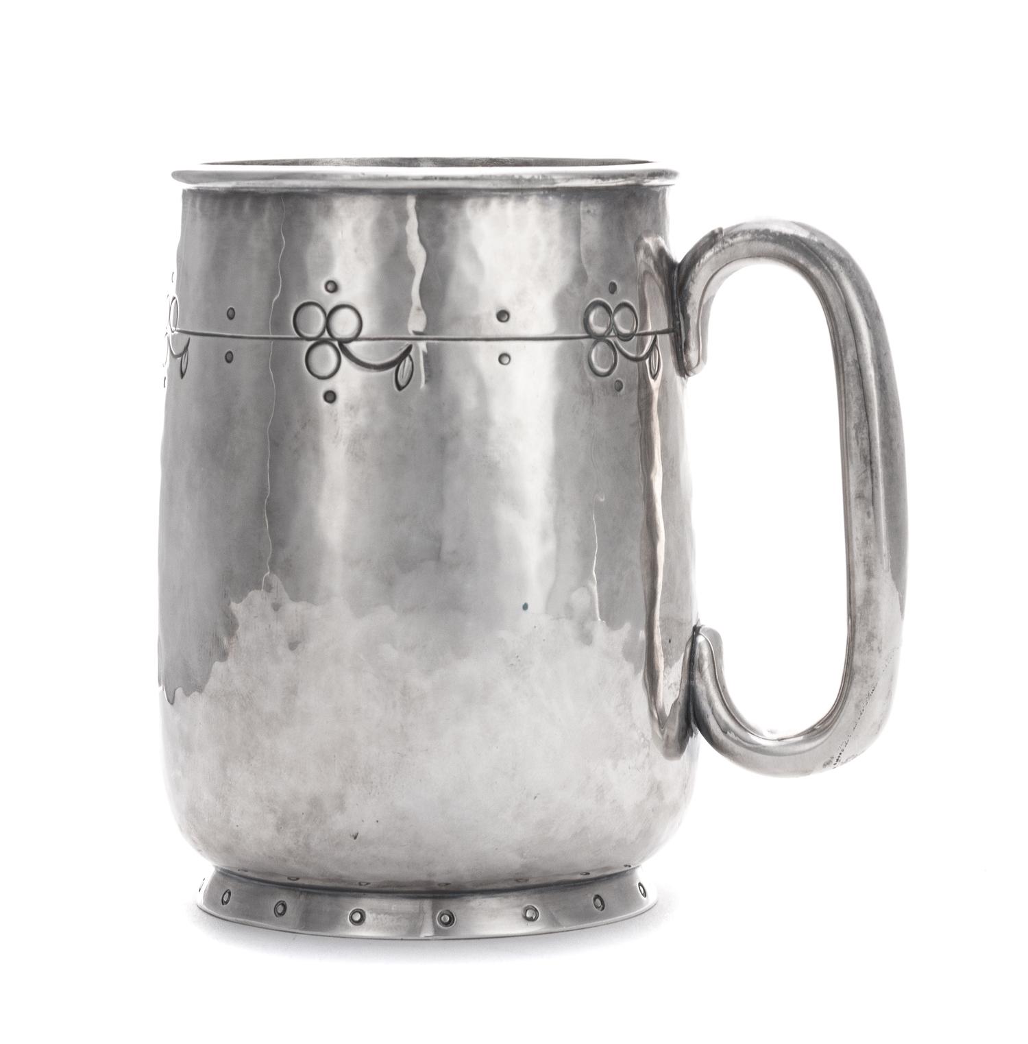 A George V Silver Mug, Liberty & Co., Birmingham, 1914, in the Arts & Crafts taste, with spot-hammered surfaces and stylized chased che