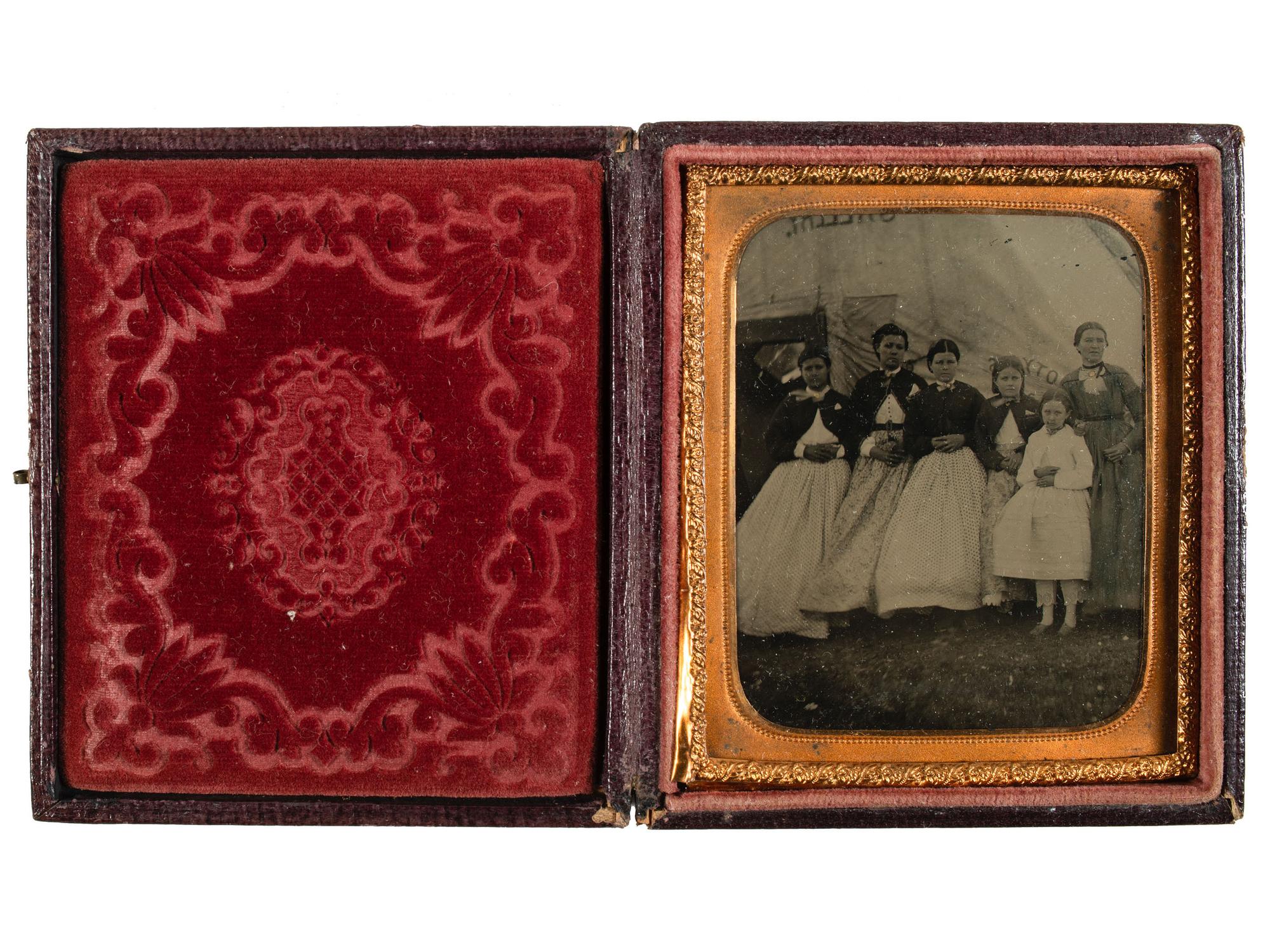 [EARLY PHOTOGRAPHY]. Tintype featuring a group of women standing outside of a Civil War photographer's tent, possibly at Camp Parole, Annapolis, MD.