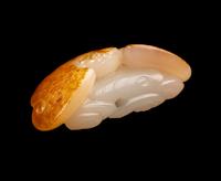A Chinese Russet and White Jade Figure of a Bat