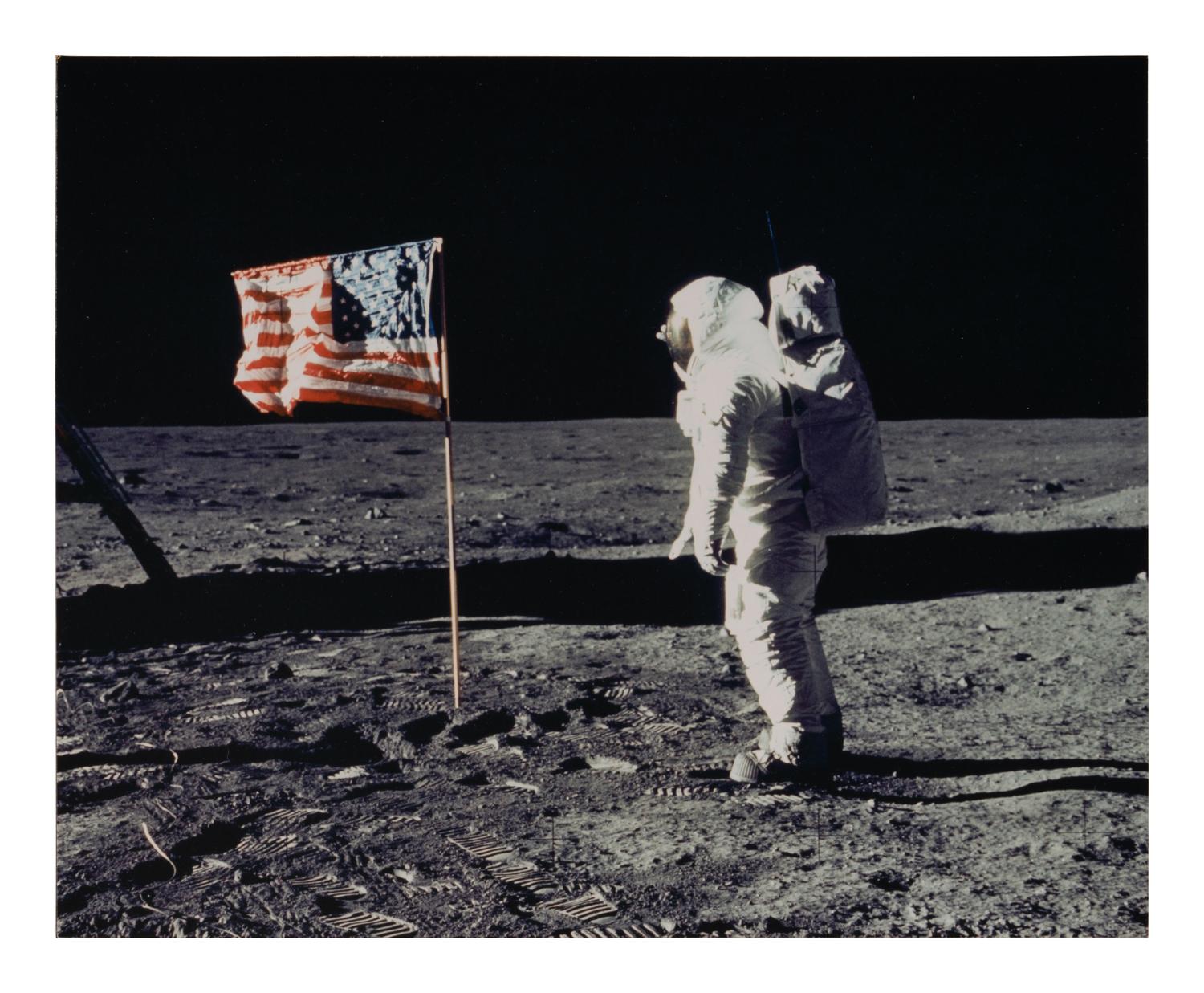 [NASA]. Photograph of Buzz Aldrin facing American flag on the moon, signed by crew members. 1969.