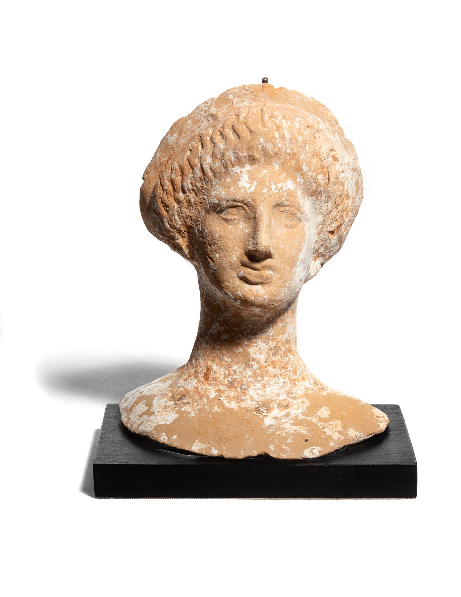 A Greek or Etruscan Terra Cotta Votive Head of a Woman