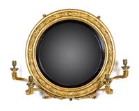 A Regency Giltwood and Ebonized Convex Girandole Mirror Height 25 x diameter 30 inches.
