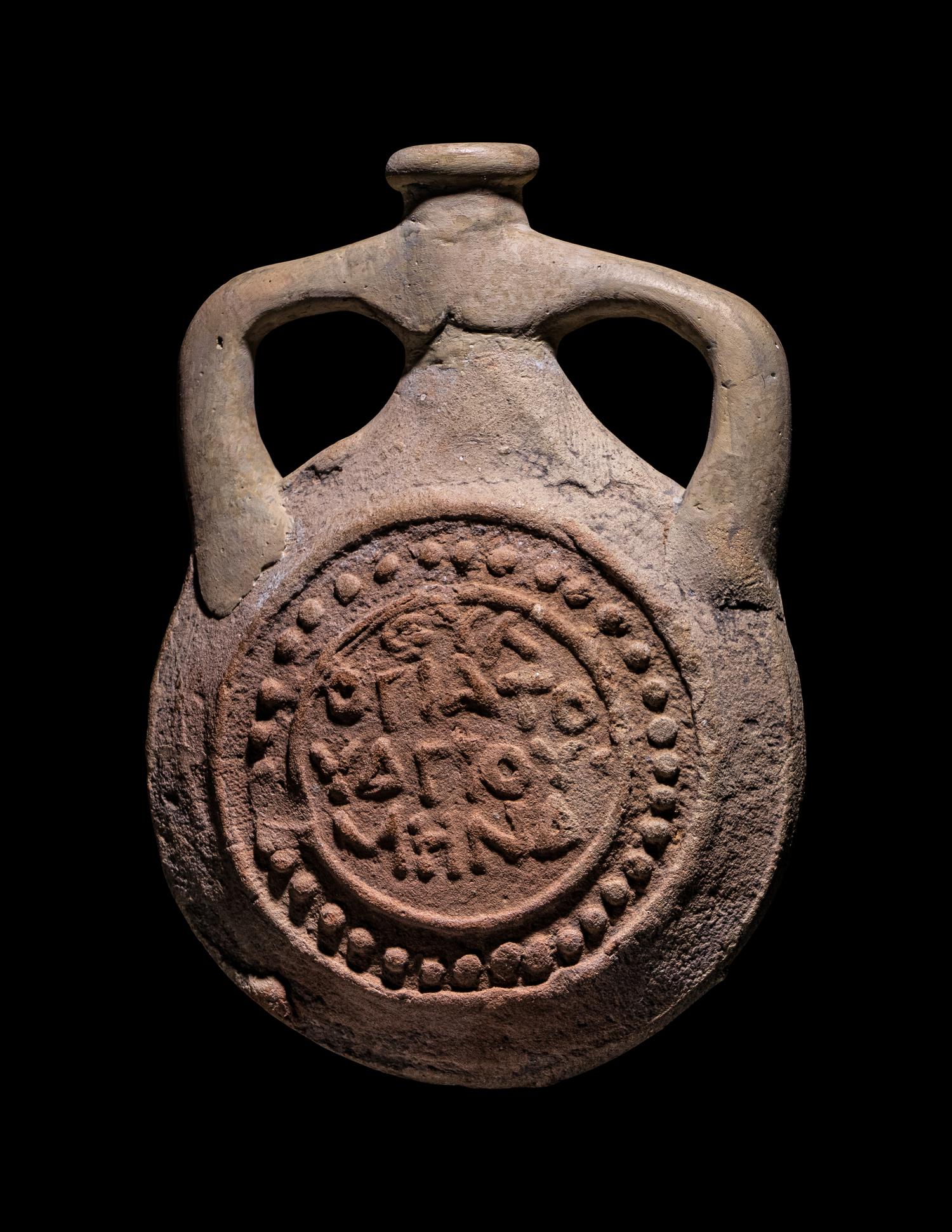 A Coptic Terracotta Pilgrim Flask with Saint Menas and Inscription