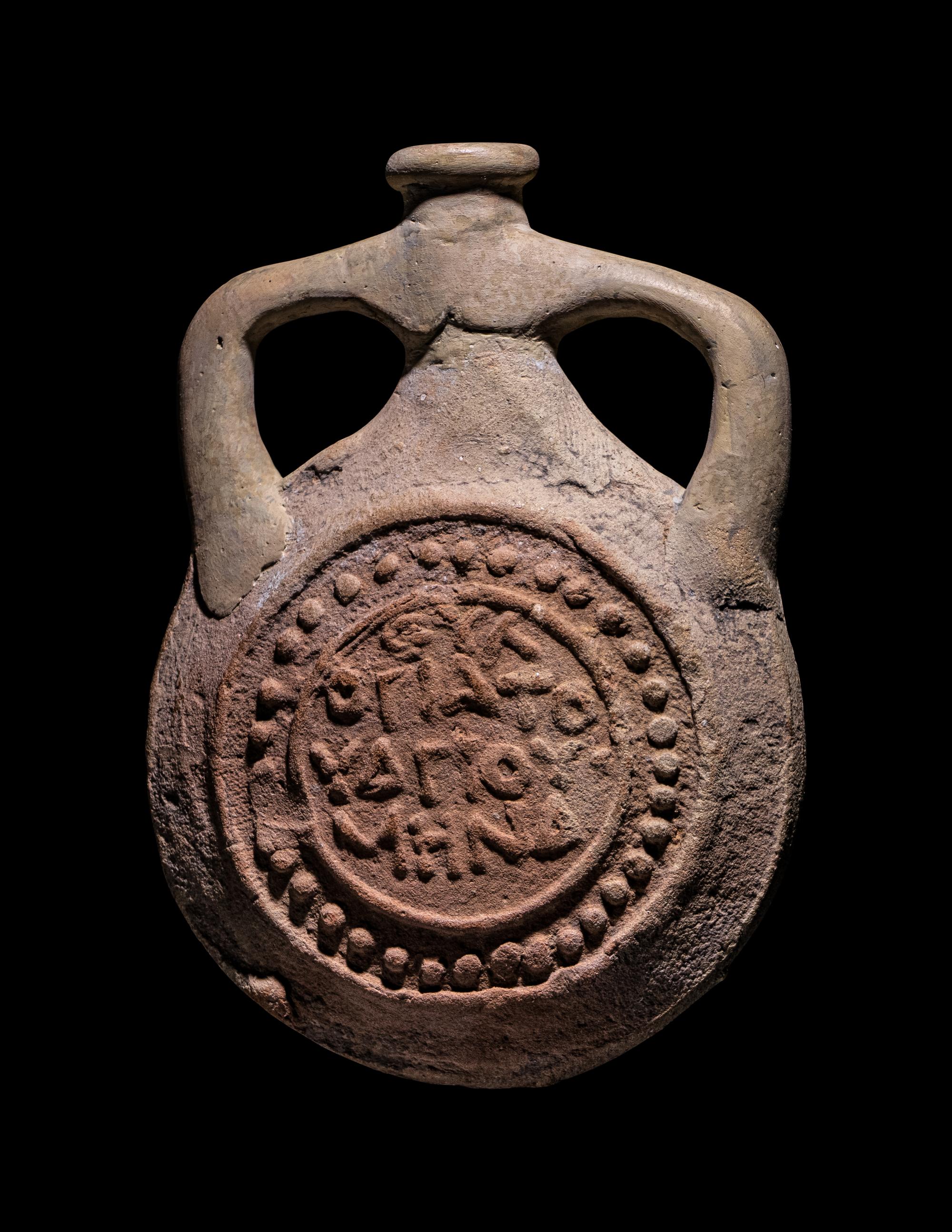 A Coptic Terracotta Pilgrim Flask with Saint Menas and Inscription