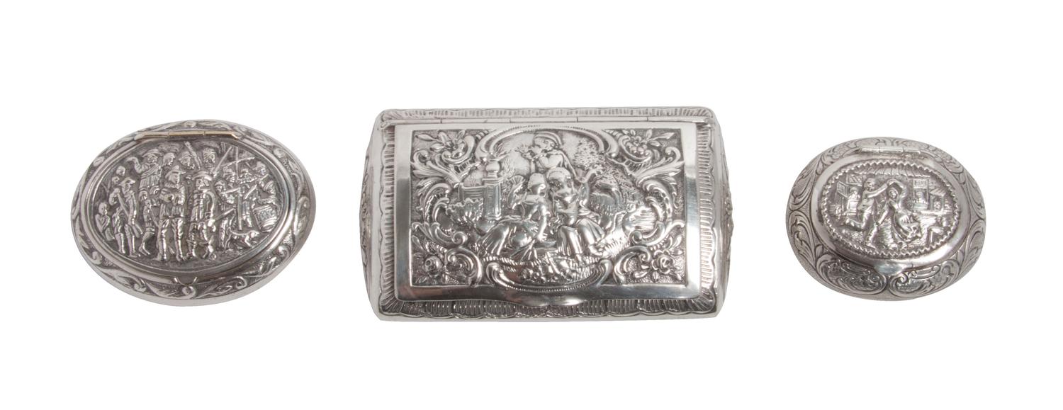 Three Silver Snuff Boxes, , one of rectangular form and two of oval form, having hinged lids chased with figural scenes and foliate scr