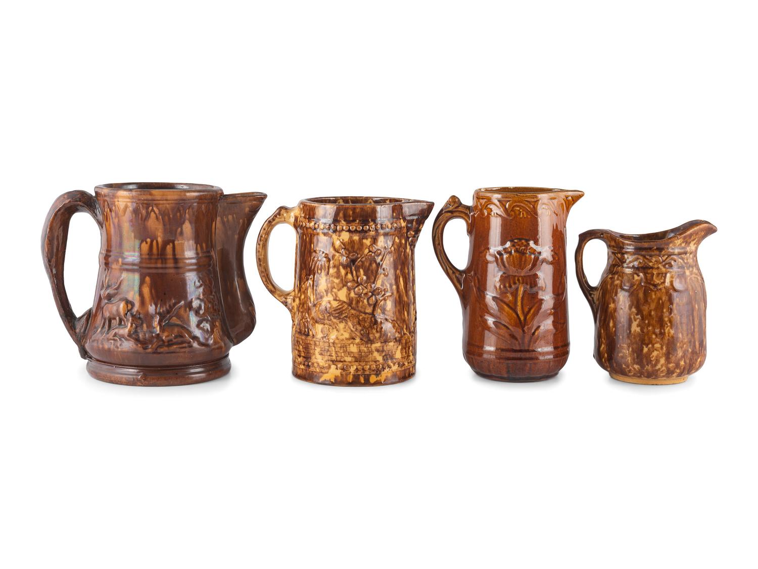 Seven Molded Yellowware Pitchers in Rockingham Glaze