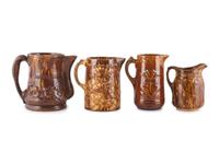 Seven Molded Yellowware Pitchers in Rockingham Glaze