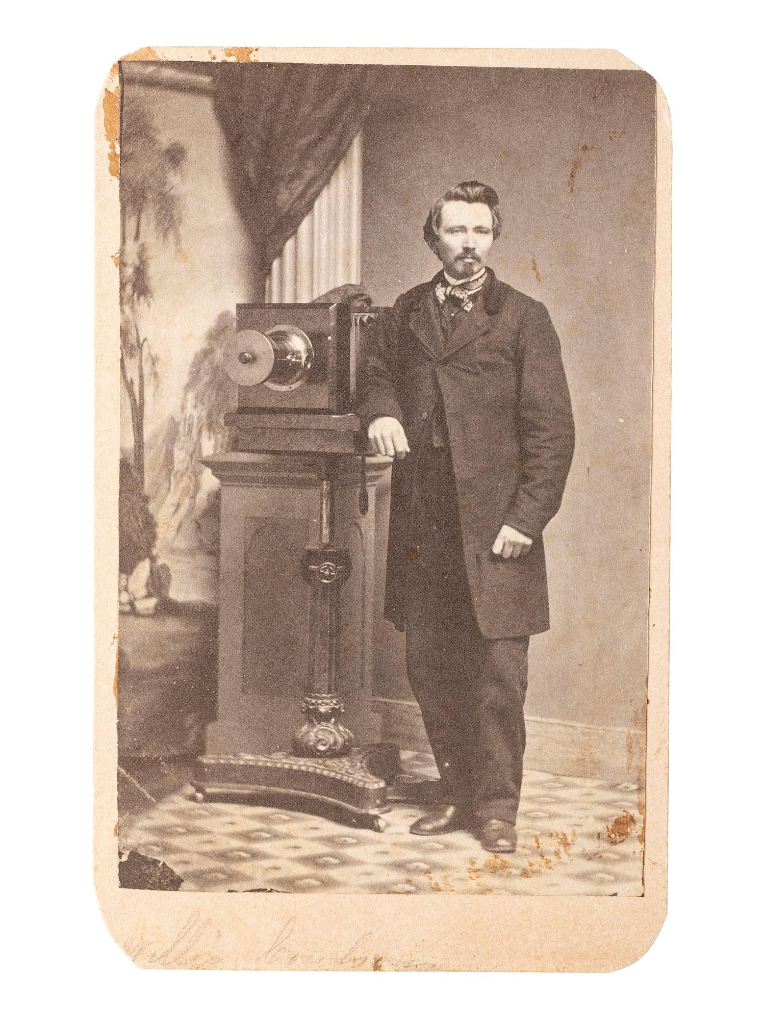 [EARLY PHOTOGRAPHY]. CDV of photographer posed with his camera in a studio.