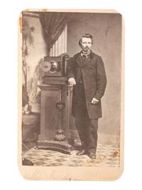 [EARLY PHOTOGRAPHY]. CDV of photographer posed with his camera in a studio.