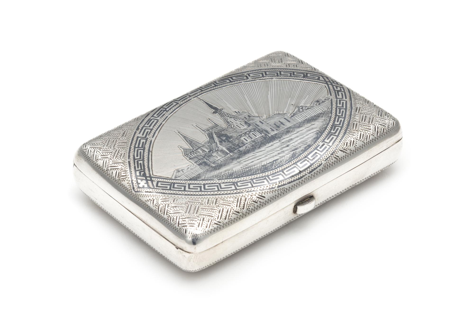 A Russian Niello Silver Cigarette Case, Maker's Mark CEC, Early 20th Century, the lid centered by a Slavic town scene, the underside wi