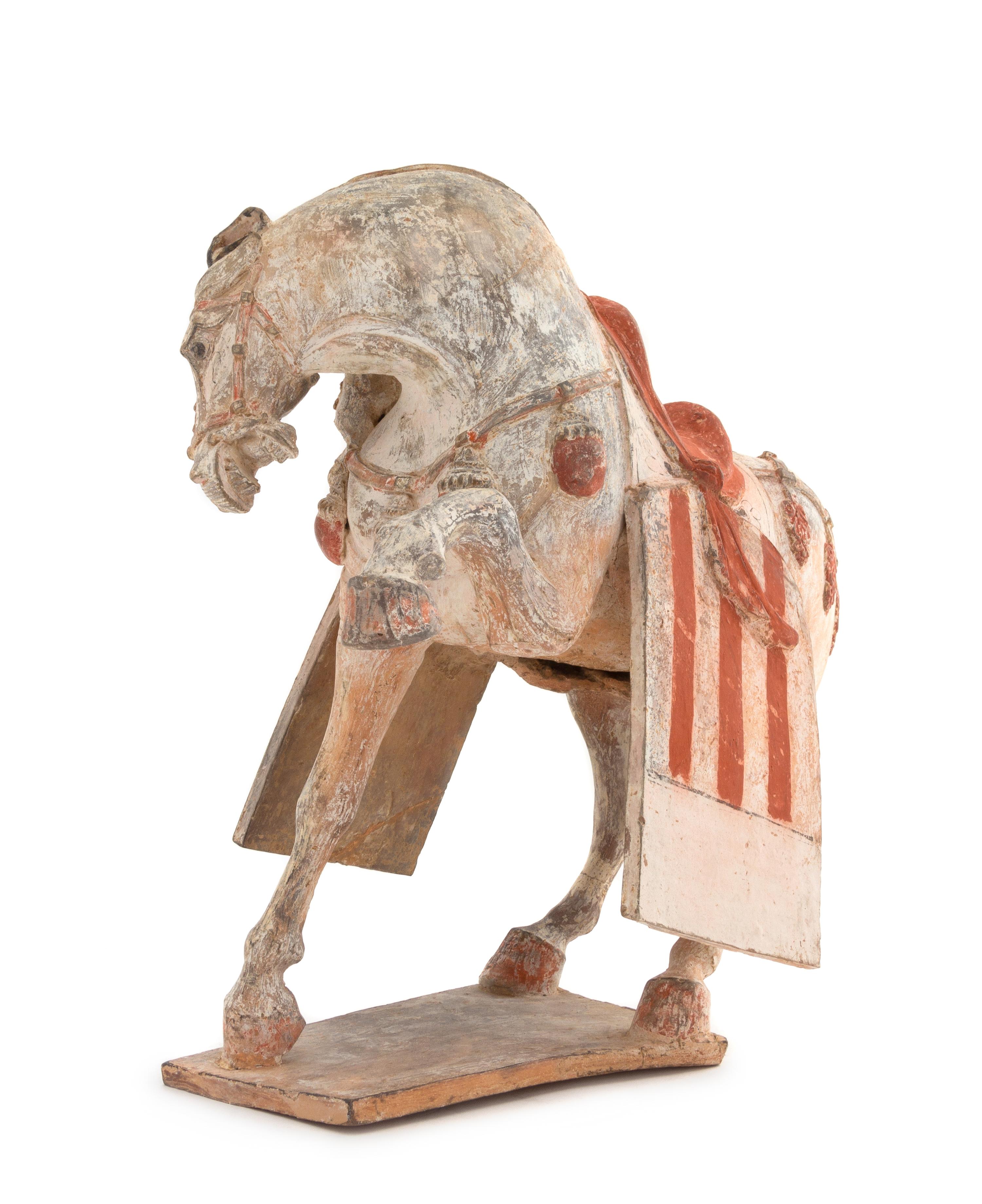 A Painted Pottery Figure of a Prancing Horse Height 12 1/2 inches. — POSSIBLY TANG DYNASTY