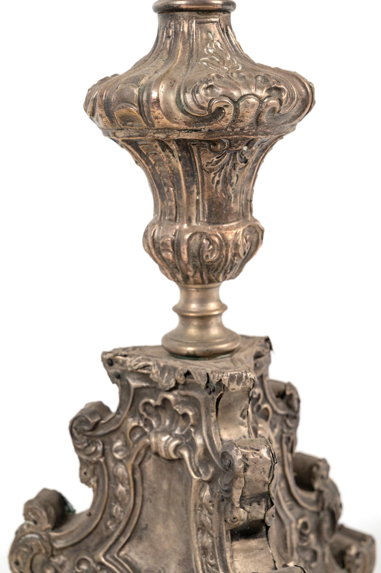 A Pair of Baroque Repoussé Decorated Silvered Metal Pricket Sticks