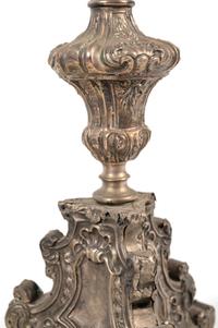 A Pair of Baroque Repoussé Decorated Silvered Metal Pricket Sticks