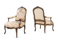 A Pair of Louis XV Style Carved Walnut Fauteuils