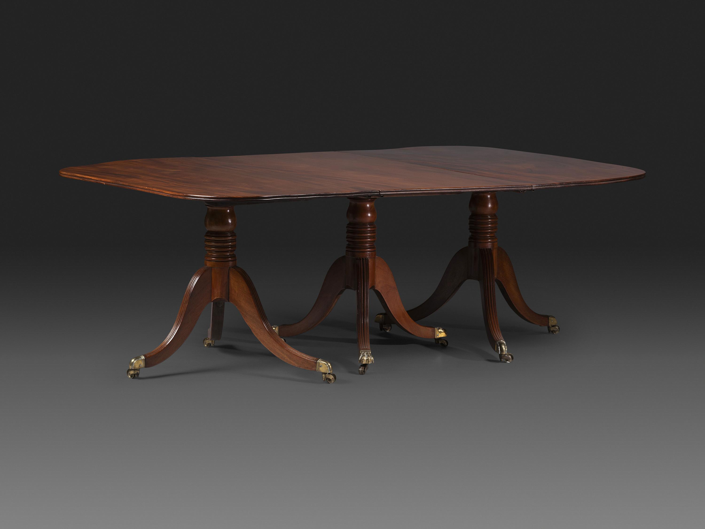 A Late Chippendale Flame Mahogany Triple Pedestal Dining Table
