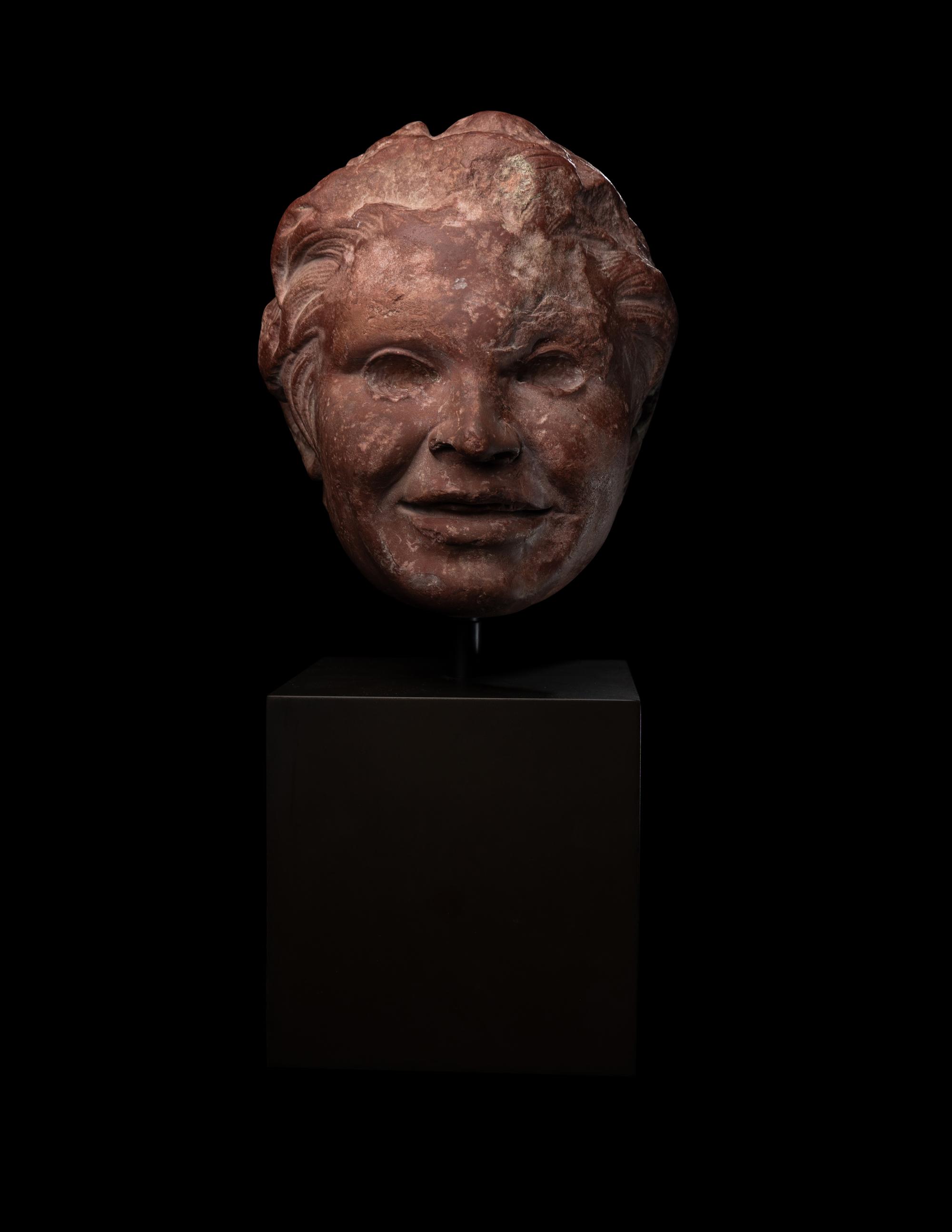 A Roman Rosso Antico Head of a Young Satyr