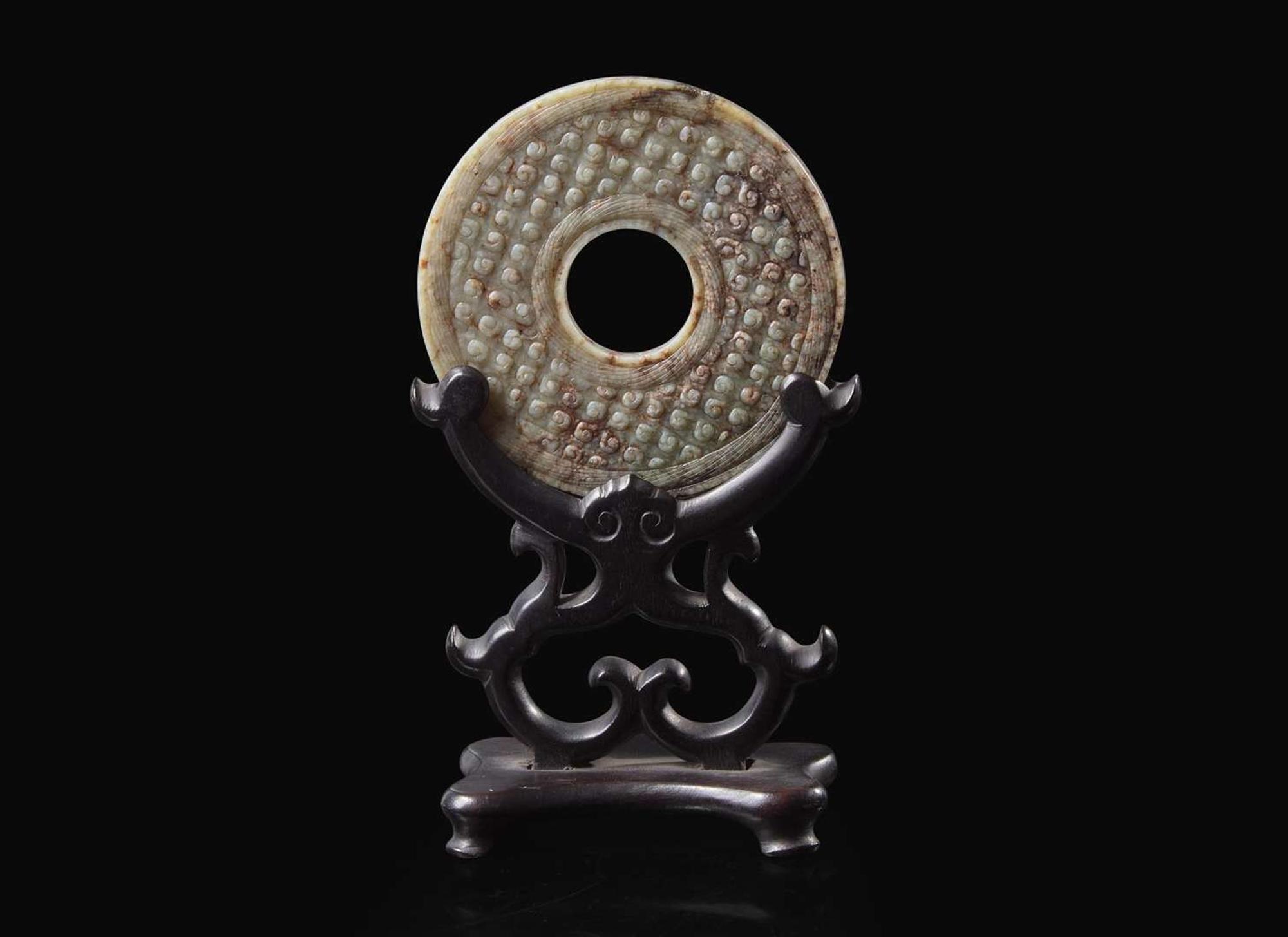A Chinese archaistic carved mottled grey and russet jade bi disc 玉璧一件