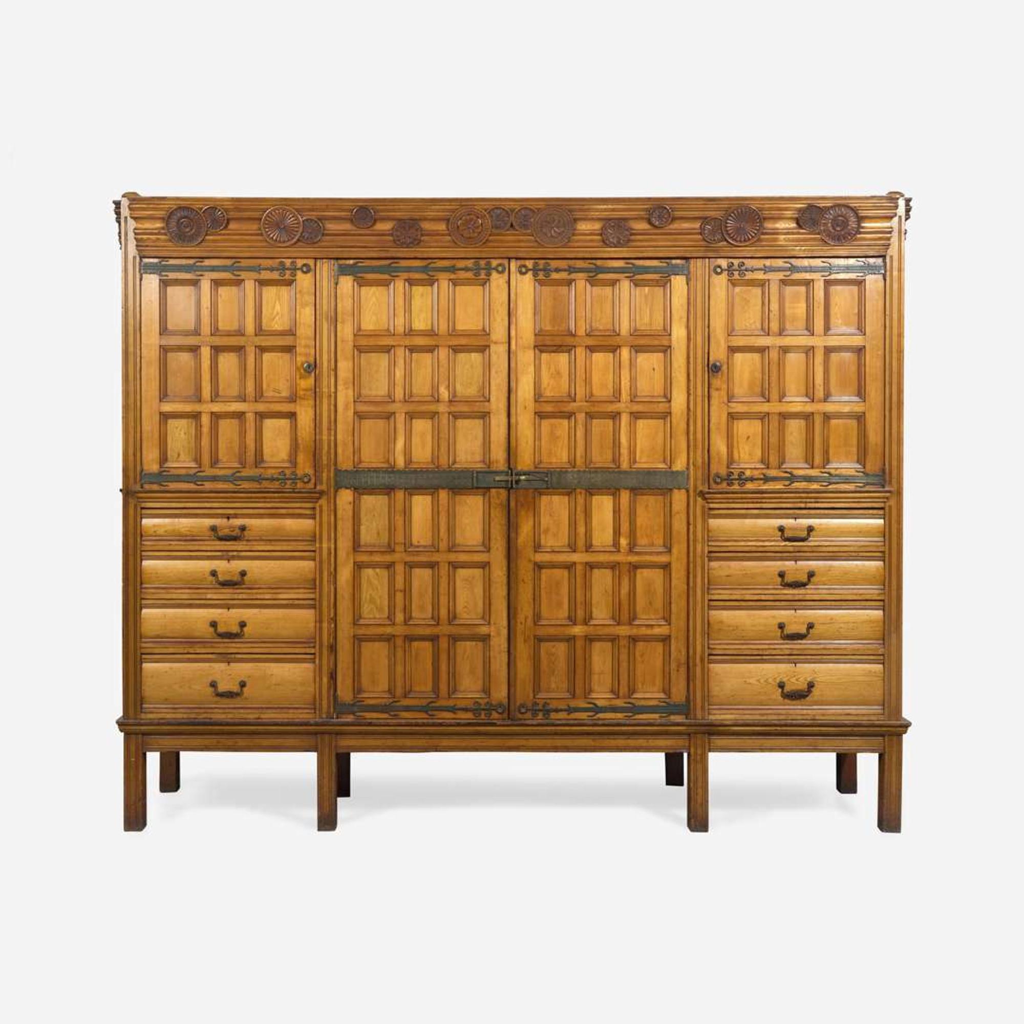 A large English Aesthetic Movement oak wardrobe Attributed to Richard Norman Shaw (1831-1912) & William Eden Nesfield (1835-1888), retailed by Maple & Co. (est. 1841), London, England, circa 1870