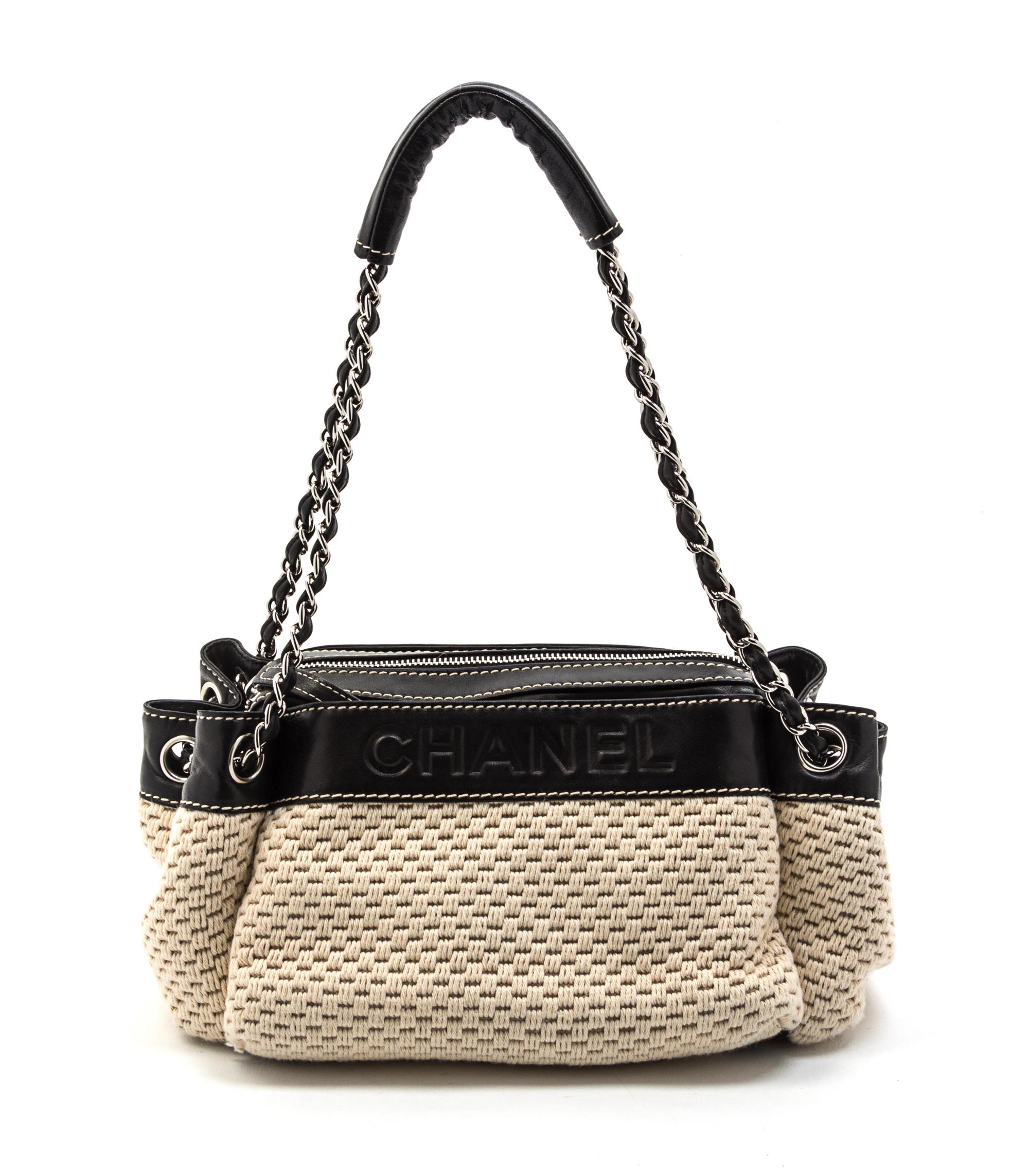 A Chanel Ivory Woven and Black Leather Trim Bag, 11 x 6 x 5 inches.