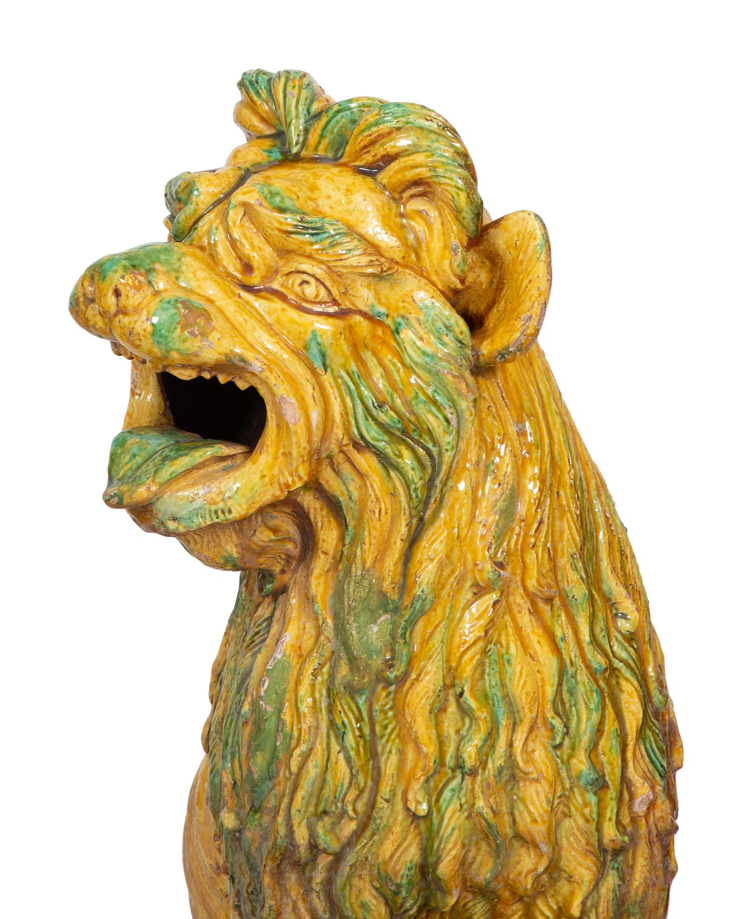 A Pair of Italian Yellow and Green Glazed Ceramic Figures of Seated Lions