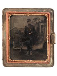 [CIVIL WAR]. Sixth plate tintype of an armed Union soldier posed before a Classically-inspired studio backdrop.