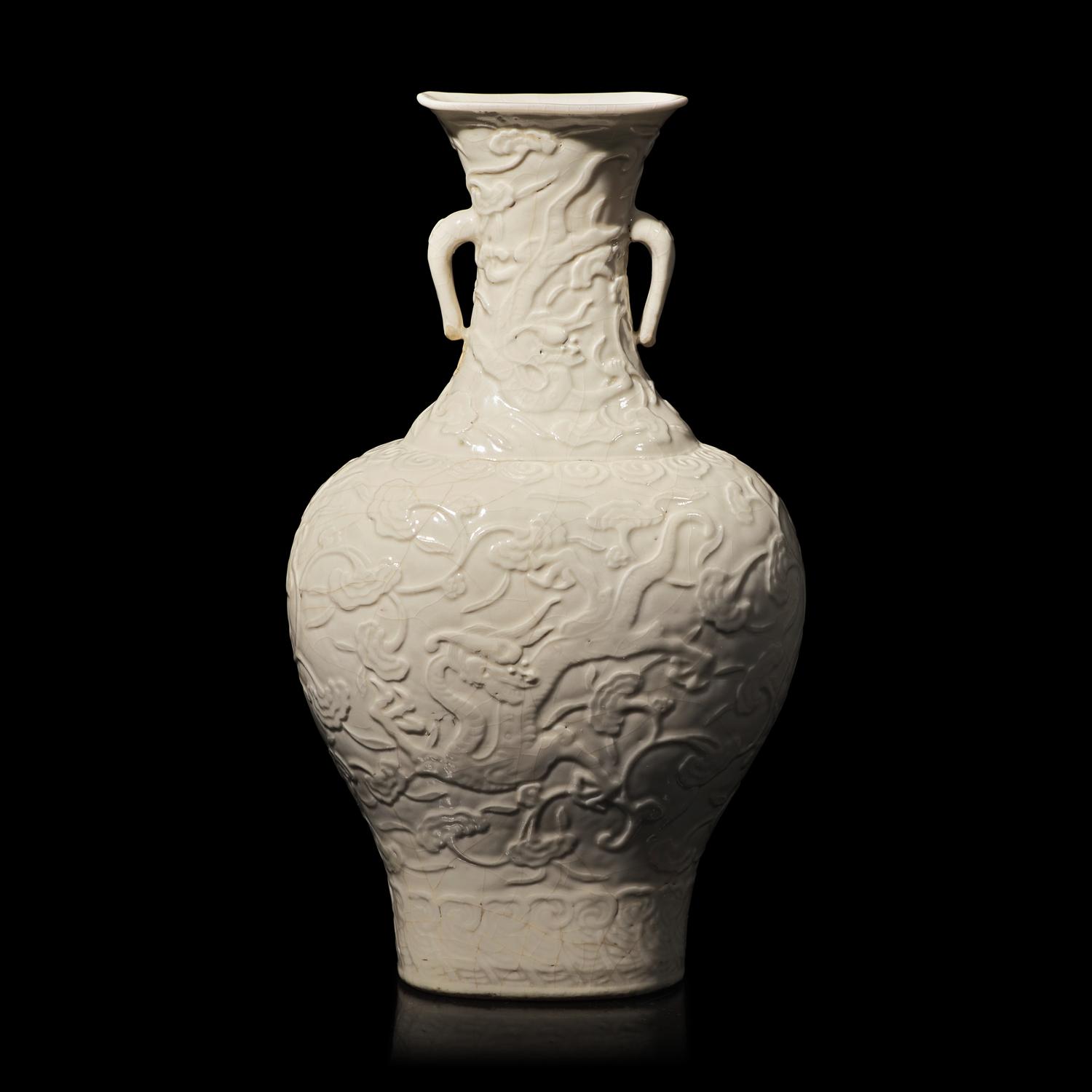 A Chinese White Glazed Soft Paste Molded 'Dragons and Lingzhi' Vase, 18th Century 清中期 白釉模印漿胎靈芝螭龍紋瓶