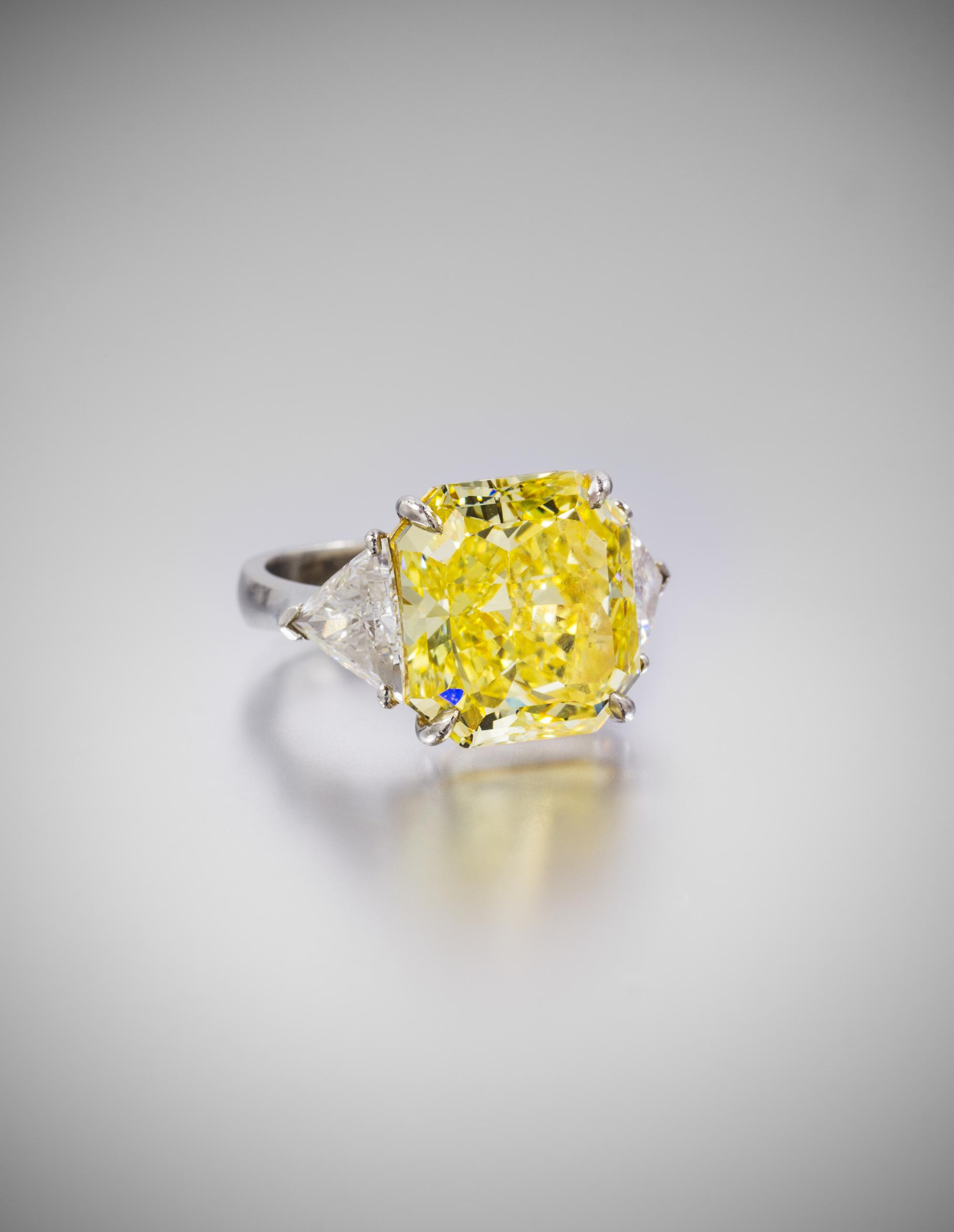 A Fine Platinum, Fancy Intense Yellow Diamond and Diamond Ring, 7.40 dwts.