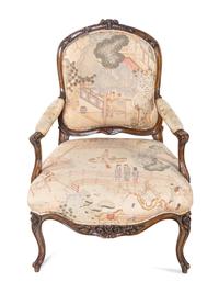 A Pair of Louis XV Style Carved Walnut Fauteuils
